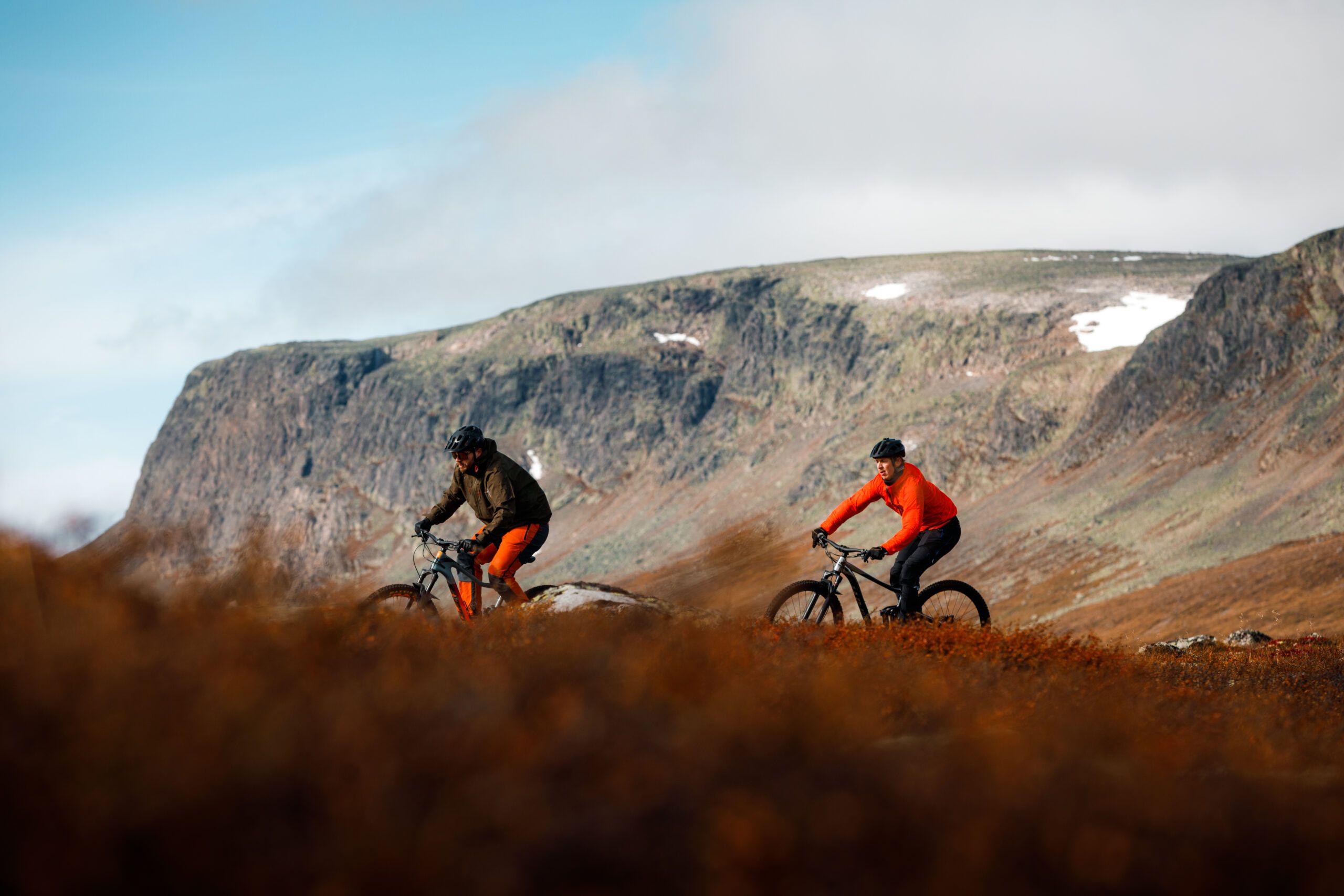 To personer sykler i høstfjellet. Foto